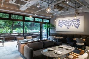 a restaurant with couches and tables and a large window at THE KNOT TOKYO Shinjuku in Tokyo