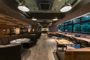 a restaurant with couches and tables and windows at THE KNOT TOKYO Shinjuku in Tokyo