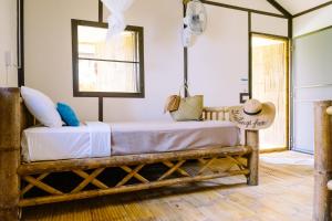 a bedroom with a bed and a window at Orion Healing Centre in Srithanu