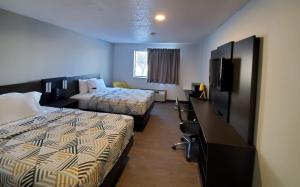 une chambre d'hôtel avec deux lits et une télévision à écran plat dans l'établissement Motel 6-Kewanee, IL, à Kewanee