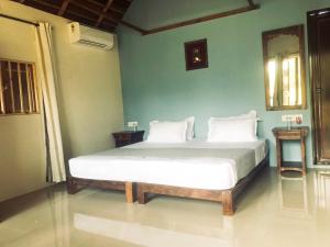 a bedroom with a large bed with white pillows at Akasa Goa in Palolem