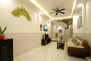 a living room with a couch and a ceiling fan at Focus Homestay in Hoi An