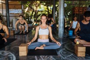 a woman is sitting in a yoga class at Orion Healing Centre in Srithanu +72 photos