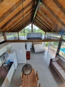 a room with a ceiling with a table and a couch at Descanso do Rosa - cabanas charmosas in Imbituba