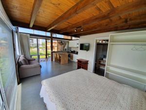 a bedroom with a bed and a living room at Descanso do Rosa - cabanas charmosas in Imbituba