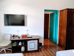 a room with a desk and a green door at Pacific Crown Hotel in Honiara