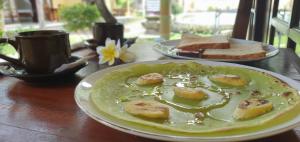 a plate of food on a wooden table with bread at Teratai Boutique Resort in Amed