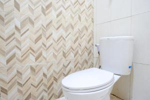 a bathroom with a white toilet in a room at RedDoorz @ Hotel Bumi Palupy in Palu +54 photos