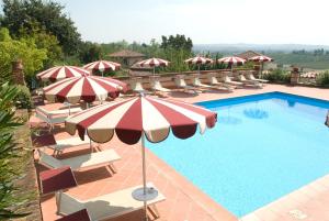 a swimming pool with umbrellas and lounge chairs and a swimming pool at Ariotto Village in Terruggia