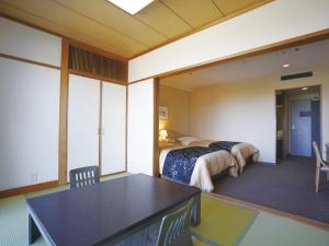 ein Schlafzimmer mit einem Bett und einem Tisch in einem Zimmer in der Unterkunft The Gran Resort Princess Arima in Kōbe