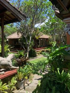 einen Garten mit einem Haus im Hintergrund in der Unterkunft Mandala Bungalows in Ubud