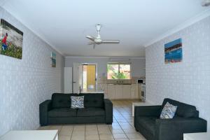 a living room with two couches and a ceiling fan at Kalbarri Seafront Villas in Kalbarri