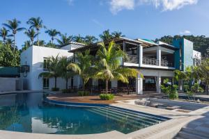 a house with a swimming pool and palm trees at Weekends El Nido Beach Resort in El Nido