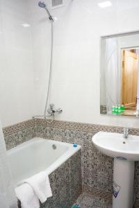 a bathroom with a bath tub and a sink at Little Bukhara in Bukhara
