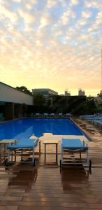 新加坡的住宿－新加坡凱煌大酒店，两张桌子和一个游泳池,位于一座天空建筑中