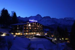 un hotel en la nieve por la noche en Aux Ducs de Savoie en Combloux
