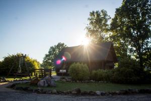 a barn with the sun shining behind it at Naktsmājas APĒ in Ape