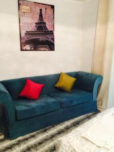 Sofá azul con 2 almohadas rojas y amarillas en Studio appartment beach front en Harqalah
