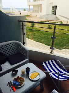a table with a plate of food on a balcony at Studio appartment beach front in Harqalah