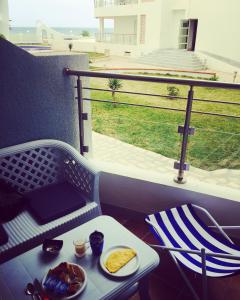 une table avec une assiette de nourriture sur un balcon dans l'établissement Studio appartment beach front, à Harqalah