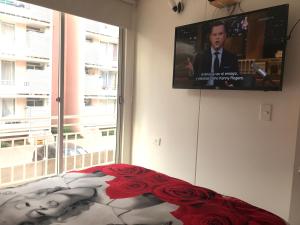 a bedroom with a flat screen tv on the wall at Cosmopolita Rojo in La Serena