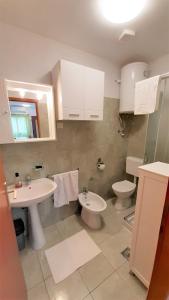 a bathroom with a sink and a toilet and a mirror at Apartments Nadia Sokolić in Nerezine