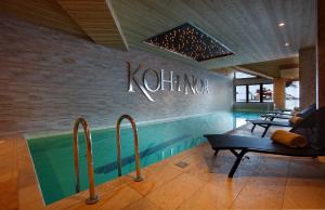 a swimming pool with a sign that reads kushima at Hôtel Koh-I Nor by Les Etincelles in Val Thorens