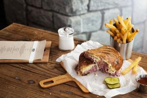 a sandwich and french fries on a wooden table at Hotel Indigo Atlanta Vinings, an IHG Hotel in Atlanta
