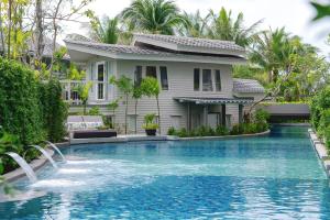 a house with a swimming pool in front of a house at Melia Koh Samui in Choeng Mon Beach