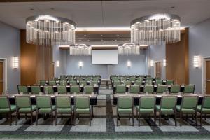 a conference room with green chairs and a projection screen at Hotel Indigo Gainesville-Celebration Pointe by IHG in Gainesville +47 photos