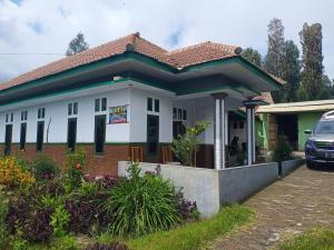 a house with a car parked in front of it at Elen Homestay by ABM in Bromo
