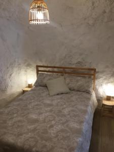 een slaapkamer met een bed met 2 tafels en een lamp bij Casa Cueva “La Estrella” in Granada