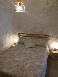 a bedroom with a bed with two tables and a lamp at Casa Cueva “La Estrella” in Granada +37 photos