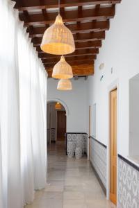 a hallway in a house with two chandeliers at BOHEMIA SANLUCAR in Sanlúcar de Barrameda