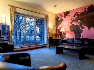 a living room with a couch and a large window at Hotel Hannover-Garbsen in Garbsen