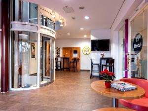 a cafe with a table and chairs and a counter at Hotel Hannover-Garbsen in Garbsen