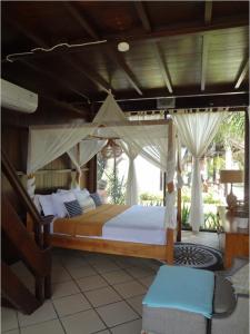 ein Schlafzimmer mit einem großen Bett mit Baldachin in der Unterkunft Le Kekeri Villas Collection in Mataram