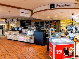 a grocery store with a red recycling machine in a store at Hotel Hannover-Garbsen in Garbsen
