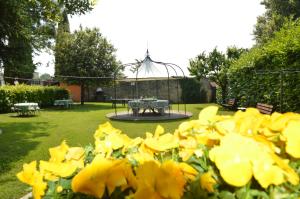 a garden with a table and yellow flowers at Agriturismo La Filanda in Manerba del Garda
