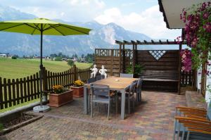 a table with chairs and an umbrella on a patio at Haus Lisa in Reith im Alpbachtal