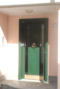 Zimmer mit grüner Tür und Spiegel in der Unterkunft Interno 4 in Alghero