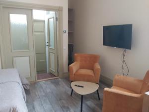 a bedroom with a bed and a chair and a television at Kesklinna Apartement in Viljandi