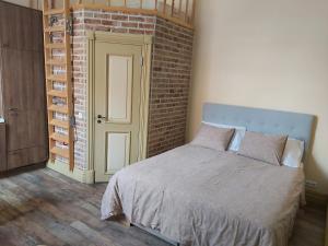 a bedroom with a bed and a brick wall at Kesklinna Apartement in Viljandi