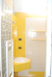 ein gelb-weißes Bad mit einem Waschbecken in der Unterkunft Interno 4 in Alghero