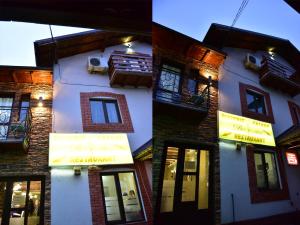 a building with signs on the side of it at Pensiunea Dely_Cios in Vălenii de Munte