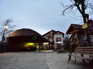 バレニイ・デ・ムンテにあるPensiunea Dely_Ciosの黒屋根の建物とベンチ付きの建物