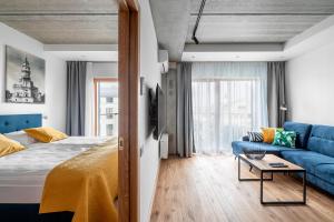 a bedroom with a bed and a blue couch at King Mindaugas Apartments in Kaunas +272 photos