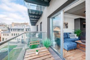 a balcony with a blue couch and a view of the city at King Mindaugas Apartments in Kaunas