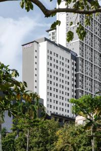 a tall white building with a sign on it at FOX Lite DPulze Cyberjaya by Ascott in Cyberjaya