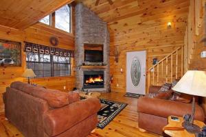 uma sala de estar com mobiliário de couro e uma lareira em Secluded Memories Cabin em McCookville